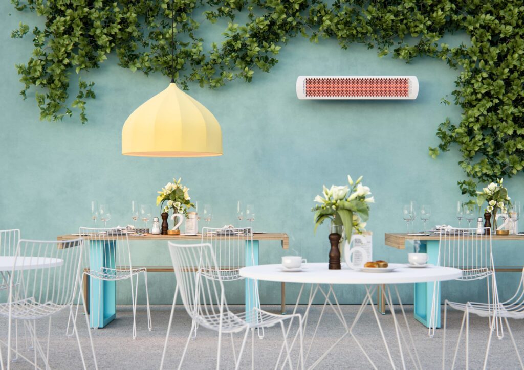 White outdoor heater on green wall in courtyard setting