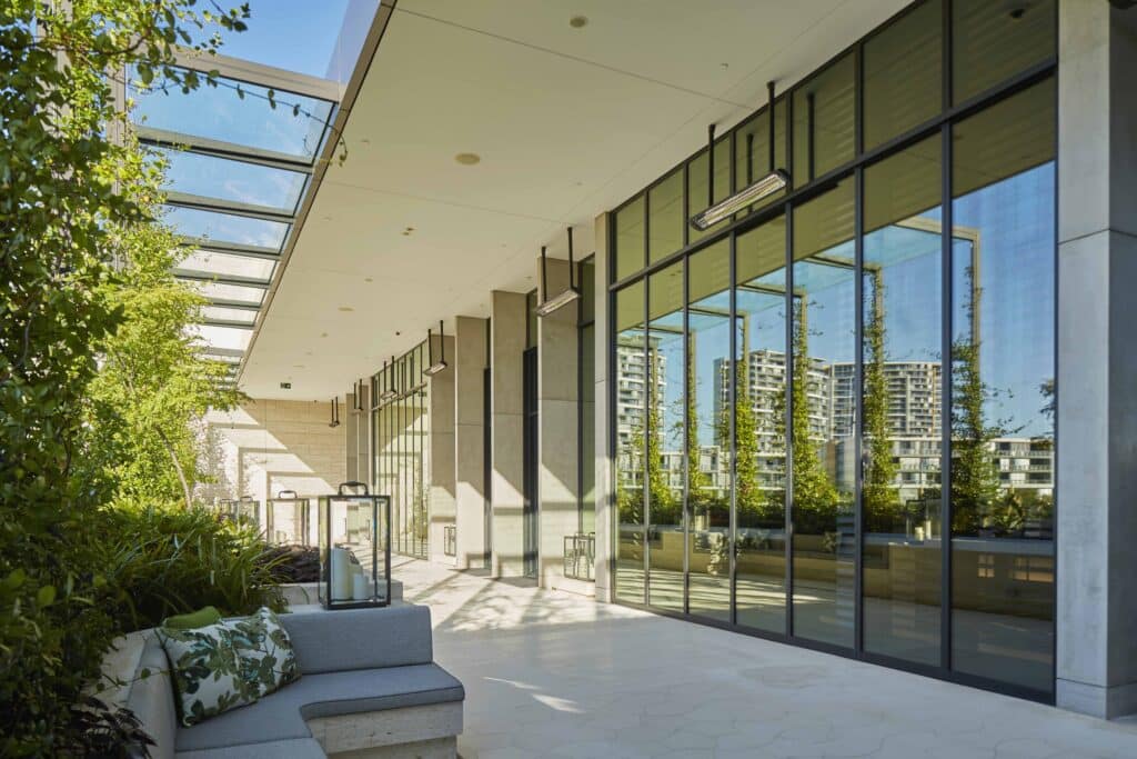 Image of refelction in glass of high rise buildings and blue skies with hanging electric heating