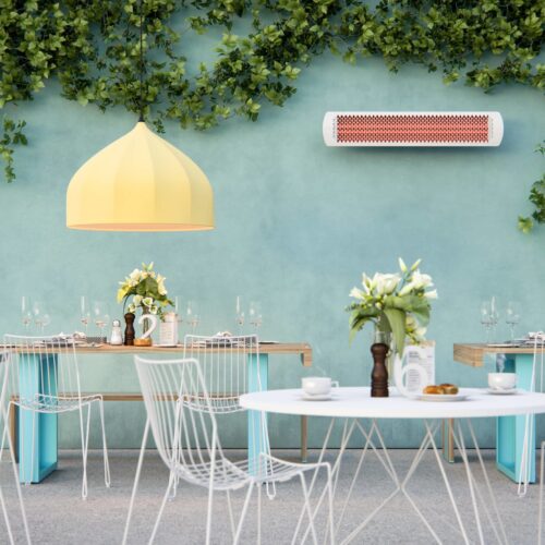 White outdoor heater on green wall in courtyard setting